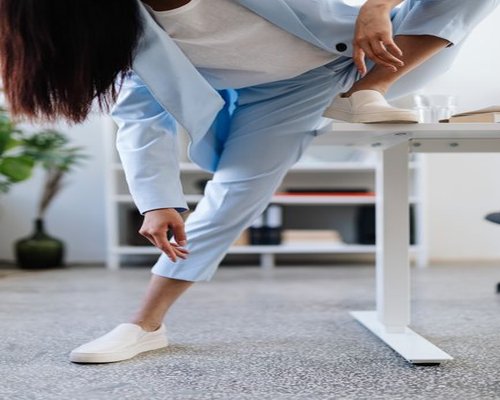 A person stretching lightly next to their modern work desk